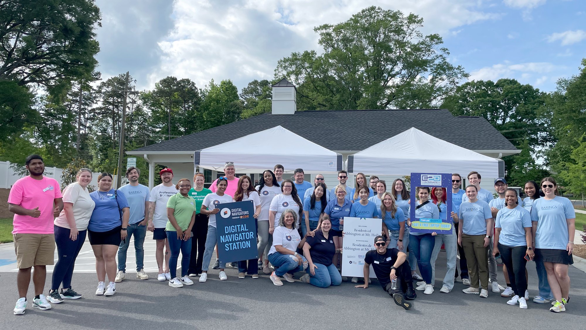 Group picture taken outdoors on a sunny day with more than 15 people from CDE, E2D, and Barings at a Laptop Distribution at an apartment complex Group picture taken outdoors on a sunny day with more than 15 people from CDE, E2D, and Barings at a Laptop Distribution at an apartment complex
